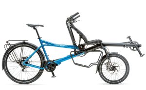 The photo shows a blue Pino tandem bike on a white background, with a standard saddle in the rear and a semi-recumbent seat in the front.