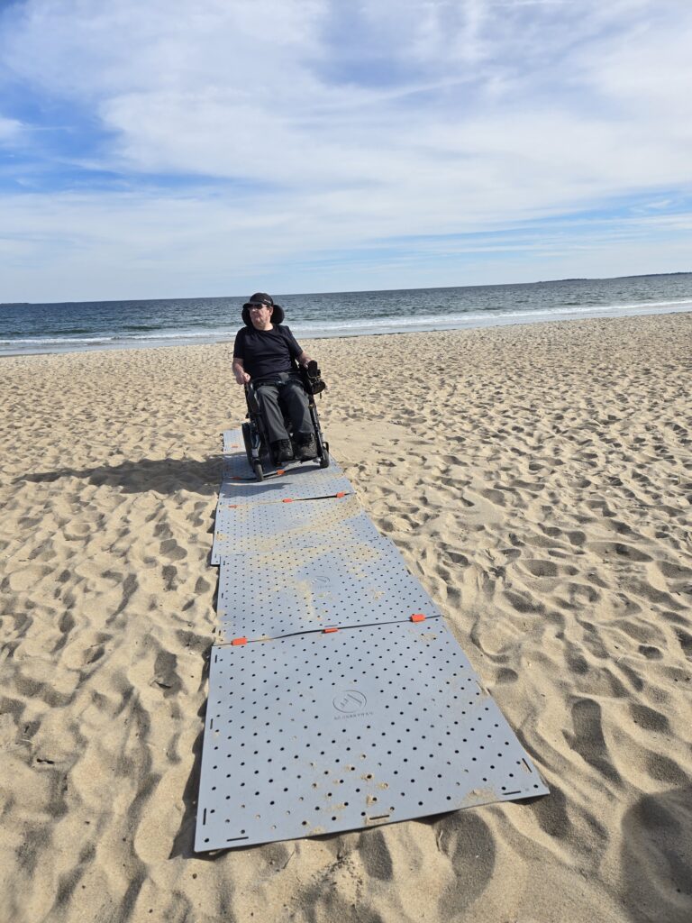 Homme en fauteuil roulant sur la plage avec le Access Trax
